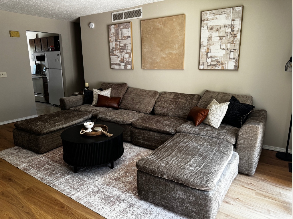 Cozy modern farmhouse styled living room with a large modular sectional sofa and warm neutrals